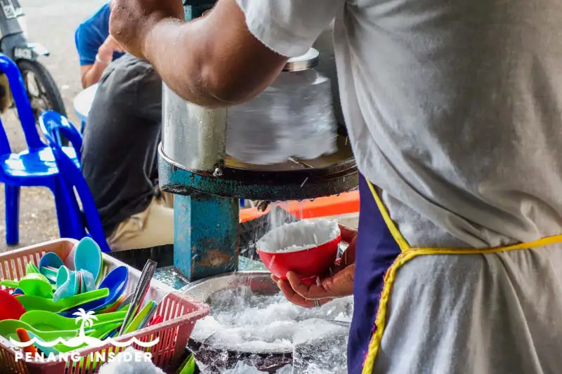 The shaving of the ice using traditional hand-operated machines at Ansari Cendol in Taiping 