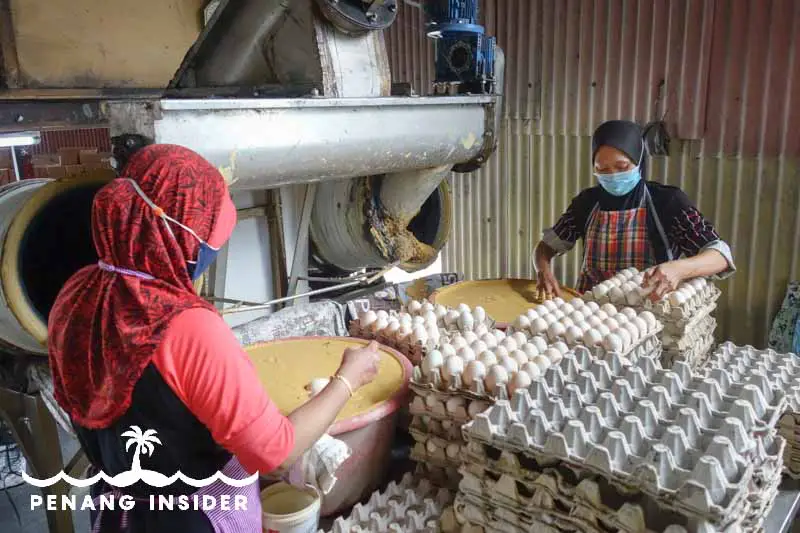 Workers at Kuala Kurau's Joo Hong Chan salted egg factory prepare the eggs to be covered in mud 