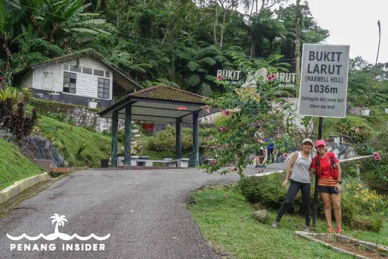 People standing in front of Bukit Larut station sign on Maxwell Hill Taiping