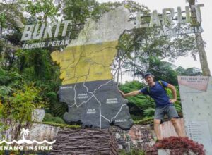 Marco Ferrarese stands next to Perak Bukit Larut sign in Taiping