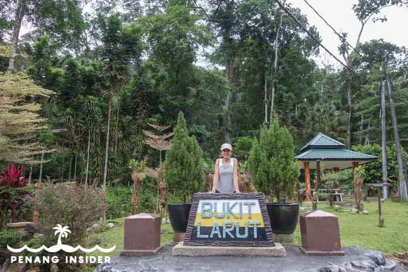 Kit Yeng Chan poses with Bukit larut sign at the bottom of Maxwell Hill in Taiping