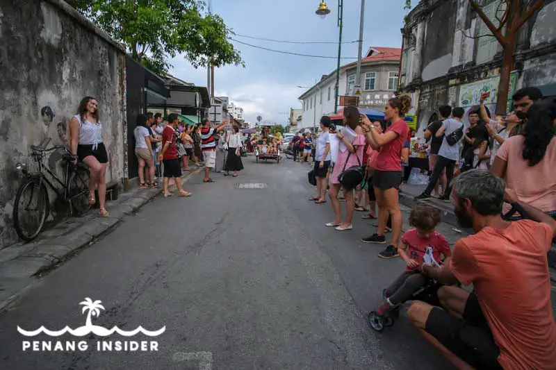 Tourists queue up to take a snap next to Ernest Zacharevic's "Little Children on a Bicycle" 