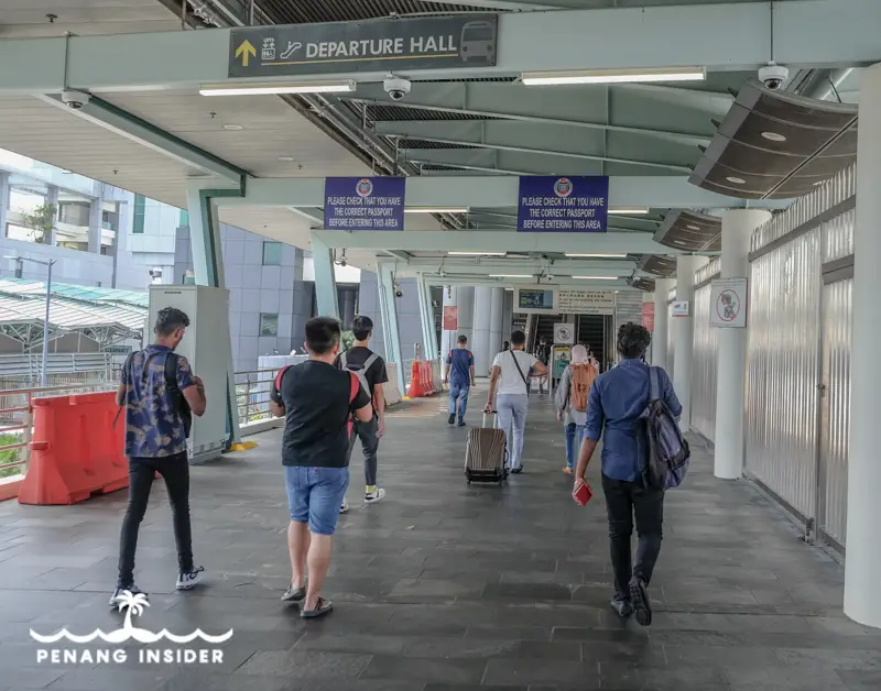 go to Malaysia from Singapore passengers walking to immigration checkpoint
